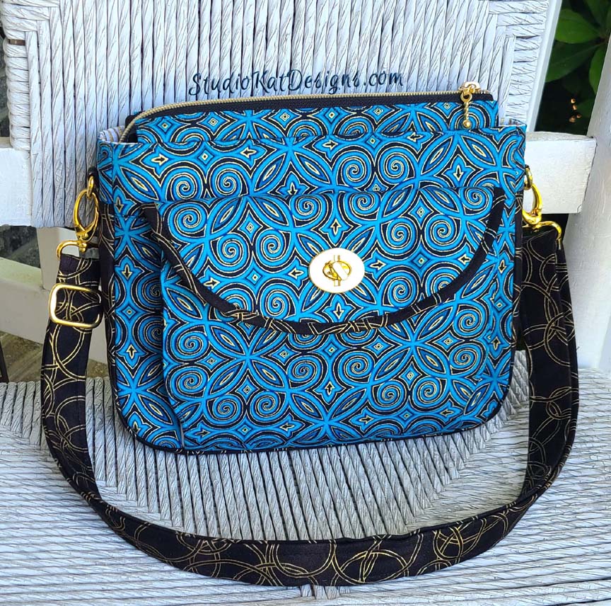 A blue and brown purse sitting on a chair.