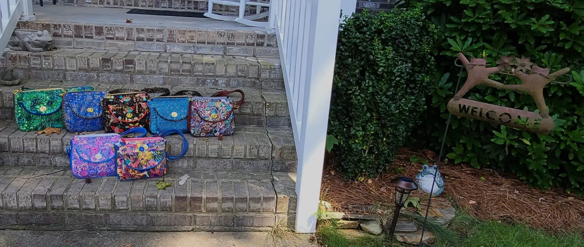 A group of colorful bags on the steps of a house.