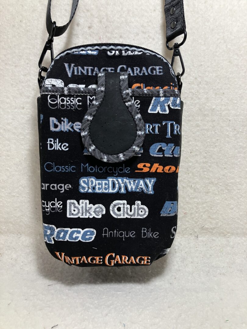 Black and white themed pouch with bike-related text and a black keychain.