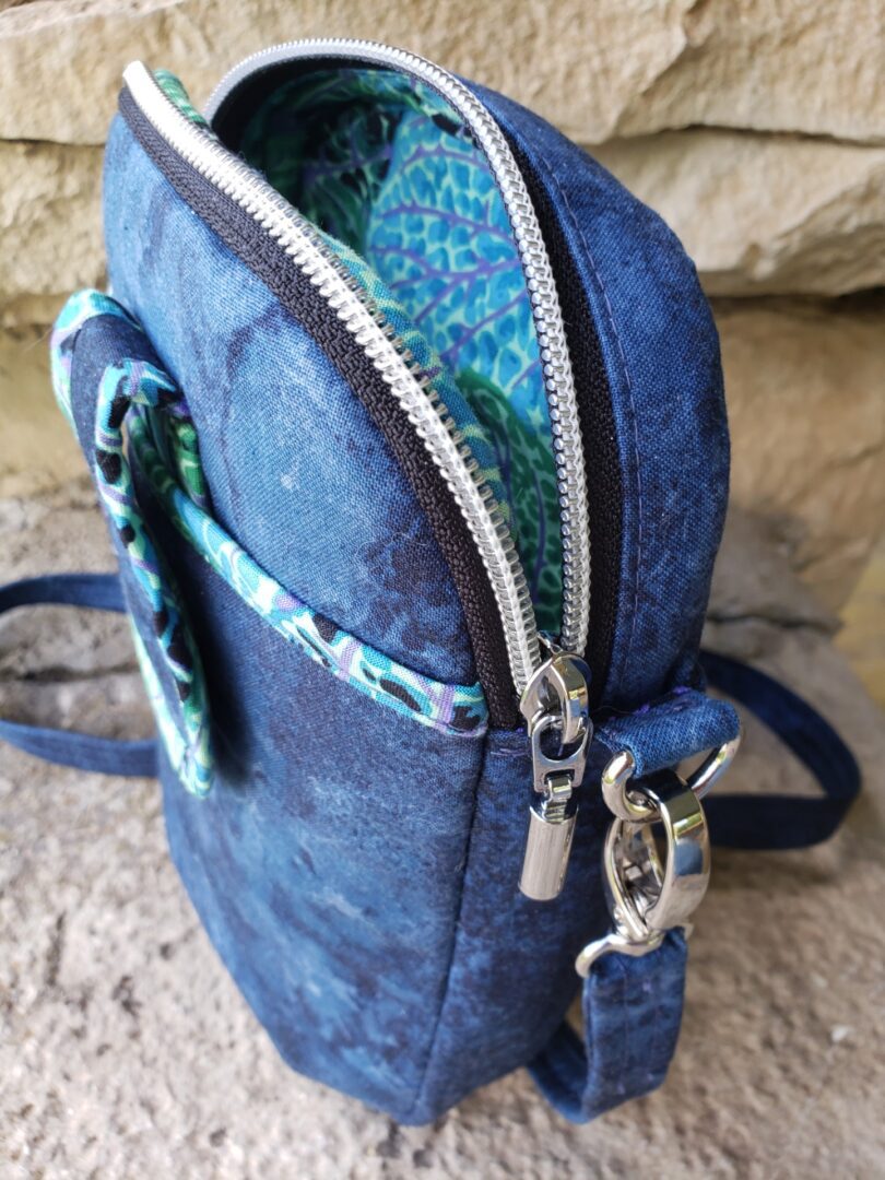 Close-up of a blue backpack zipper and strap detail.