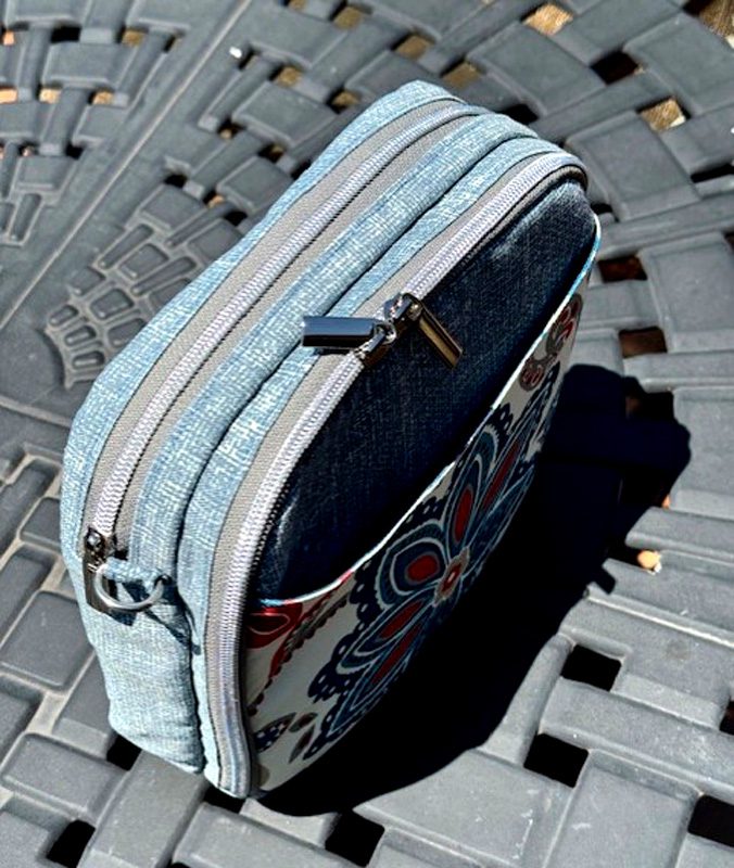 A fabric pouch with a zipper on a textured surface.