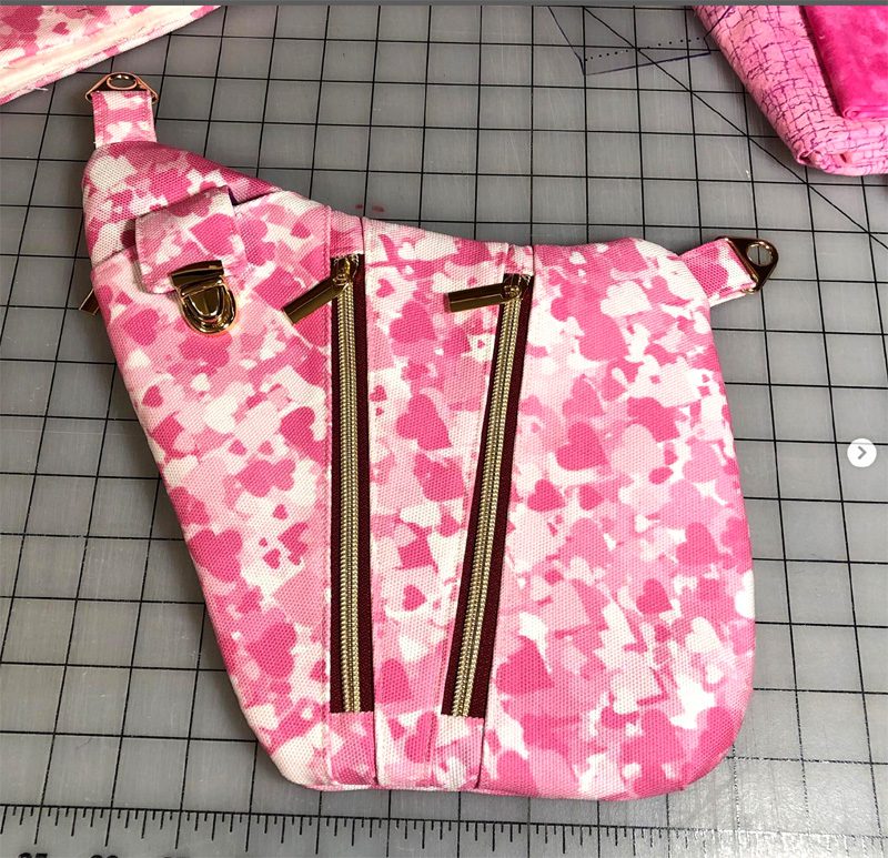 Pink camouflage fabric with zipper and two long metal rods.