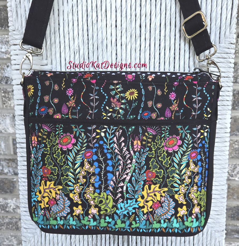 Colorful floral embroidery on a black fabric bag.