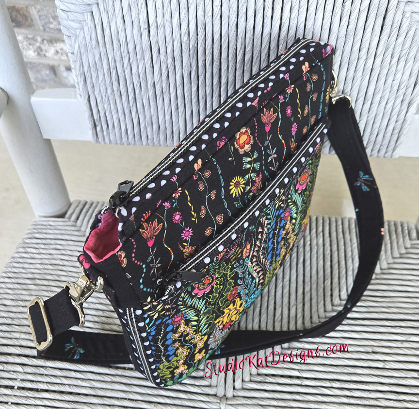 Colorful embroidered crossbody bag with floral patterns and a black strap.