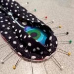 A polka dots fabric with pins all over its sides
