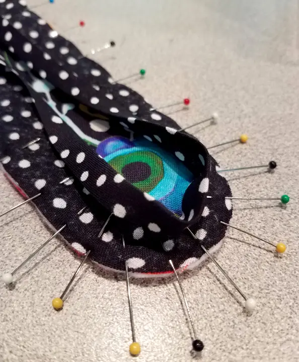 A polka dots fabric with pins all over its sides