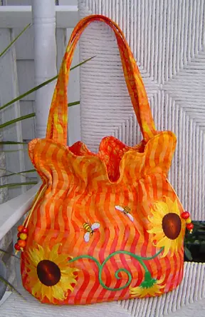 An orange handbag with sunflower design