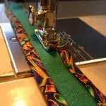Sewing the plain green strap and the colorful fabric