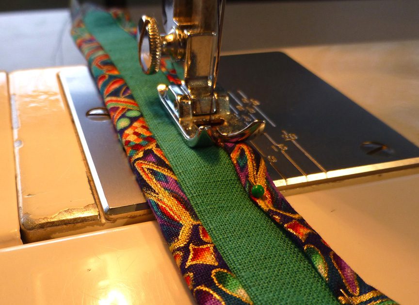 Sewing the plain green strap and the colorful fabric