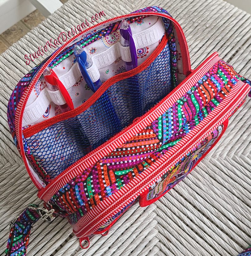 The pen holder inside the colorful sling bag with red zippers