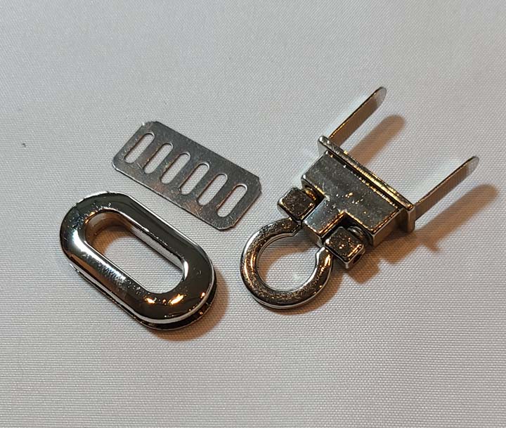 A pair of metal clasps and a metal ring on a white surface.