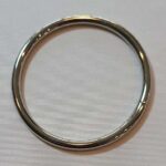A silver ring on a white surface.