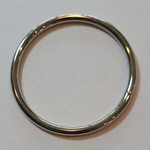 A silver ring on a white surface.