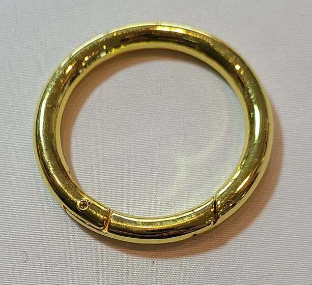 A gold plated ring on a white surface.