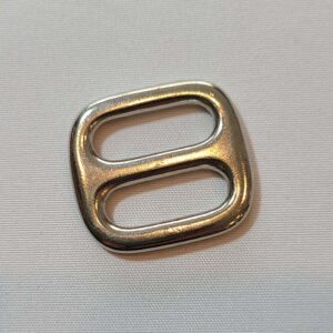 A silver metal buckle on a white surface.