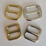 A set of four metal buckles in different colors.