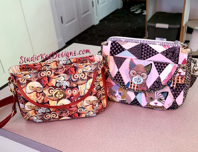 Two purses with owls on them are sitting on a counter.