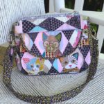 A quilted bag with cats on it.