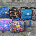 A group of colorful handbags sitting on a set of steps.