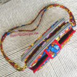 A colorful purse with a strap on it.