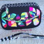 A black cross body bag with a colorful design on it.