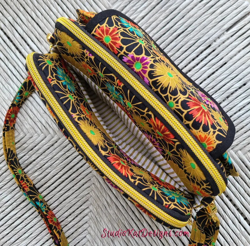 A black and yellow purse with a floral pattern.