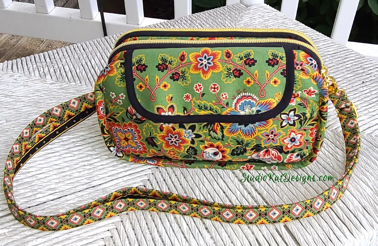 A green purse with a floral pattern on it.