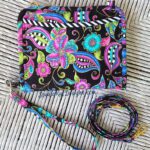 A colorful purse with a lanyard attached to it.