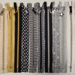 A row of different colored zippers on a white background.