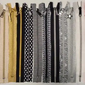 A row of different colored zippers on a white background.