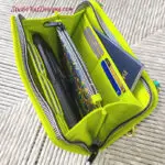 A green zippered bag with several items inside.