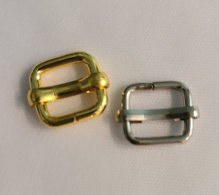 Two metal buckles on a white surface.
