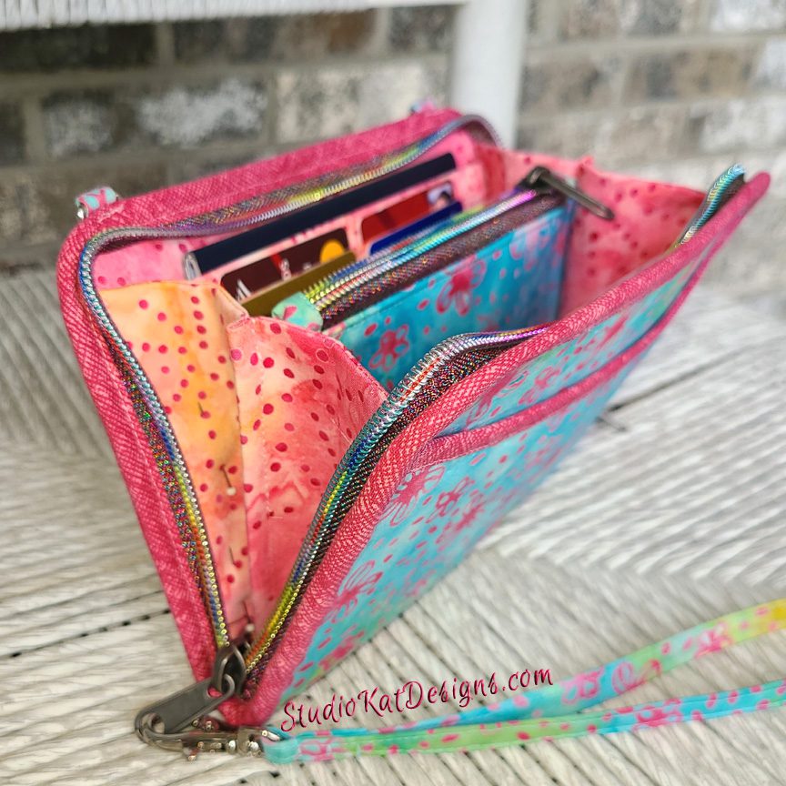 A pink and blue purse with a zippered pocket.