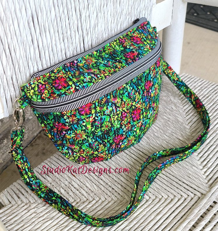 A colorful floral fanny pack sitting on a chair.