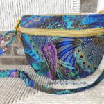A blue and purple purse with a gold zipper.