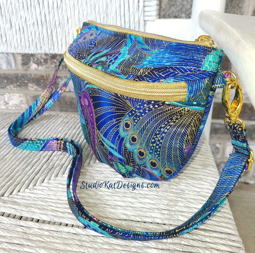 A blue and gold purse on a chair.