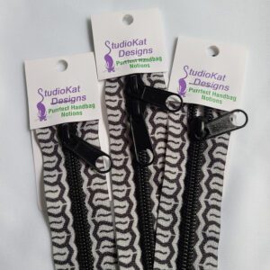 Three black and white zippers on a white background.