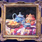 A painting of a tea pot and other things in a frame.