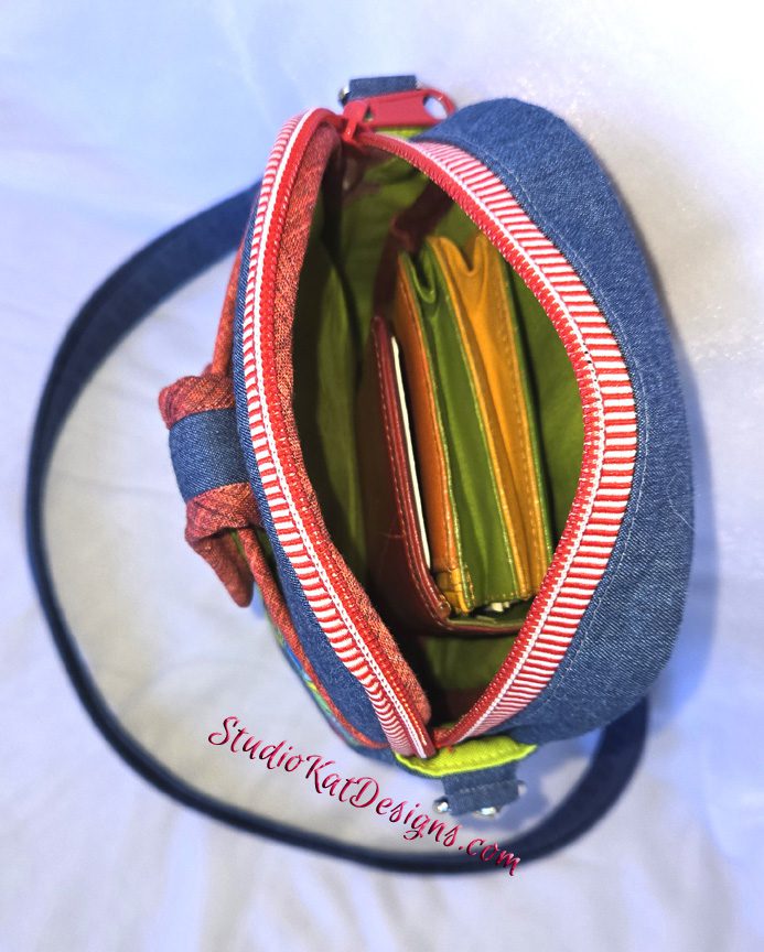 A purse with many different colored pencils inside of it