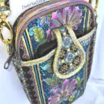 A cell phone case with a strap and a flower design. A cell phone case with a strap and a flower design.