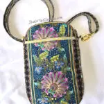 A purse that is sitting on the ground. A purse that is sitting on the ground.