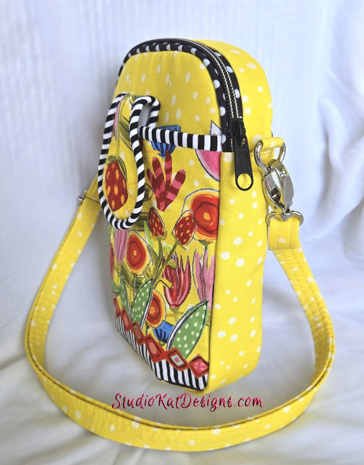 A yellow purse with flowers and polka dots.