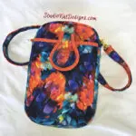 Small floral crossbody bag with vibrant colors and adjustable strap. Small floral crossbody bag with vibrant colors and adjustable strap.