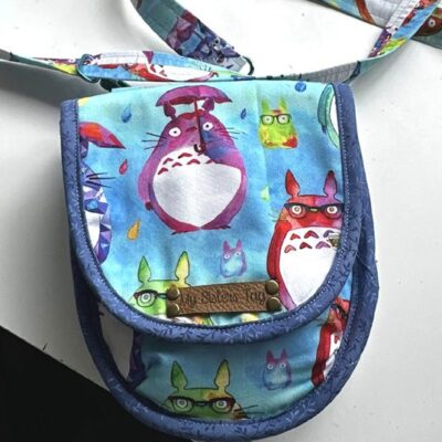 Small blue purse with colorful Totoro characters printed on it.