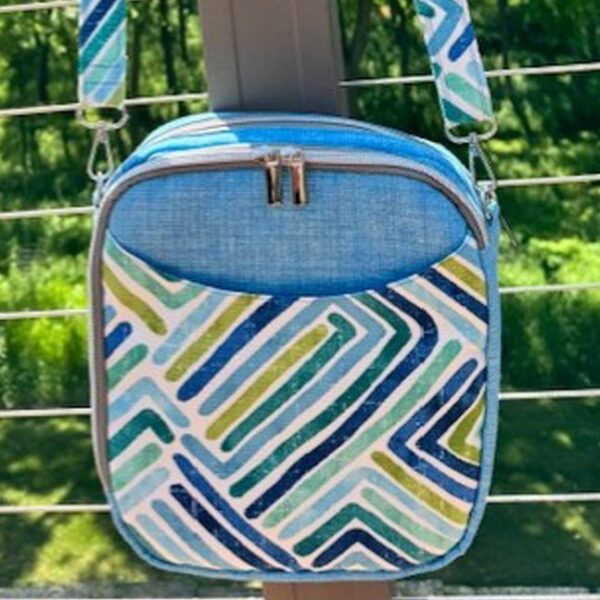 Small crossbody bag with colorful geometric pattern and blue zipper.
