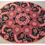 Round rug with pink floral and paisley patterns on black background. Round rug with pink floral and paisley patterns on black background.