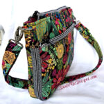 Colorful floral patterned shoulder bag with multiple zippers and compartments.