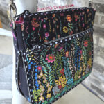 Intricately embroidered black bag with colorful floral patterns.